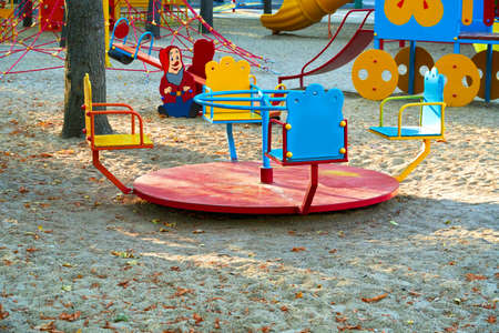 children's playground in a city Park early in the morning, various swings and carouselsの写真素材