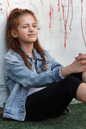 portrait of a beautiful teenage girl posing against a brick wallの写真素材