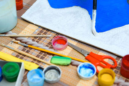 watercolor paints and paper closeup for drawing, artistic creation at home, workspace for make...
