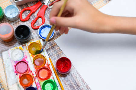 a girl drawing watercolor on a blank white paper, artistic creation at home, makes creative artworkの写真素材