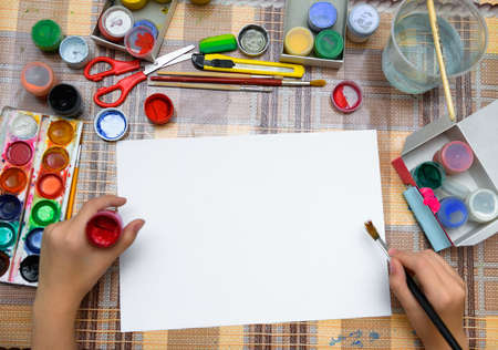 a girl drawing watercolor on a blank white paper, artistic creation at home, makes creative artworkの写真素材