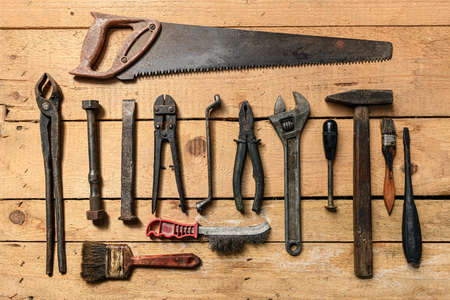 Variety of old vintage household hand tools still life on a wooden background in a DIY and repair conceptの写真素材