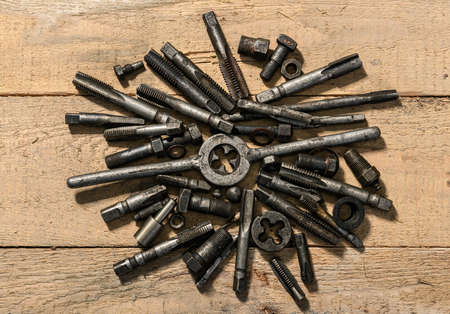 Old vintage drills and threading die tools on a wooden background