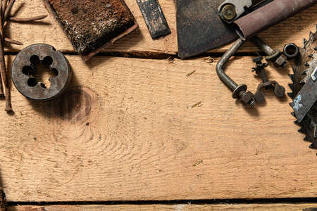 Old vintage household hand tools on a wooden background as frame and place for text