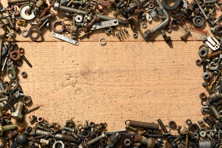 frame with blank space or place for text from old vintage hand tools, screws and nuts on a wooden backgroundの写真素材
