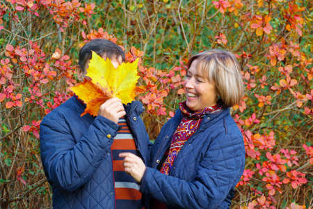 couple walking in autumn city park, happy people together, beautiful nature with colorful leaves