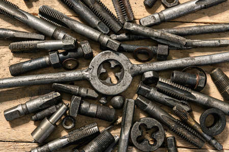 Old vintage drills and threading die tools on a wooden backgroundの写真素材