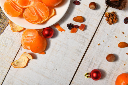 sweet food background for christmas or holiday decoration - tangerines, nuts and dried fruits on woodの写真素材