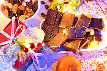sweet food top view background for merry christmas or new year holiday decoration with night illumination - chocolate candies, tangerines, cookies on white woodの写真素材