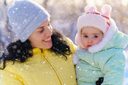 family portrait in the winter forest, mother and child, bright sunlight and shadows on the snow, beautiful nature.の写真素材