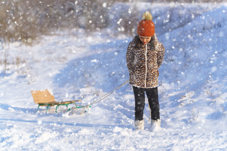 child girl throws up snow and playing in the winter forest, bright snowy fir trees, beautiful nature.の写真素材