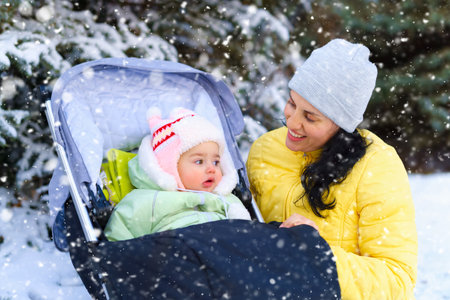 family portrait in the winter forest, mother and baby, bright snowy fir trees, beautiful nature.の写真素材