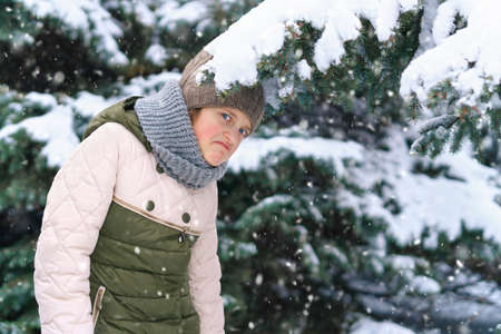 child girl playing with snow in the winter forest, bright snowy fir trees, beautiful nature