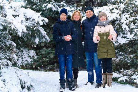 family portrait in the winter forest, parent and children, beautiful nature with bright snowy fir...
