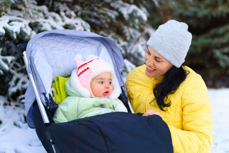 family portrait in the winter forest, mother and child, bright sunlight and shadows on the snow,...