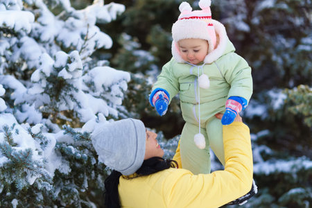 family portrait in the winter forest, mother and child, bright sunlight and shadows on the snow, beautiful nature.の写真素材