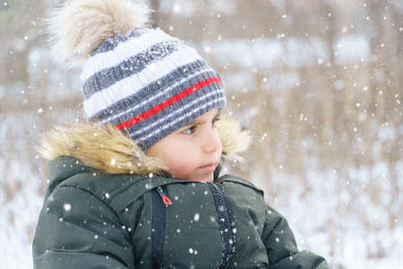 child boy portrait in winter outdoor, bright snowy forestの写真素材