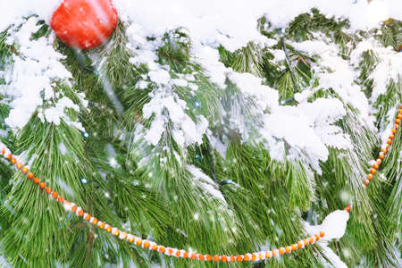christmas or New Year decorations covered with snow on the street on the Christmas tree close view