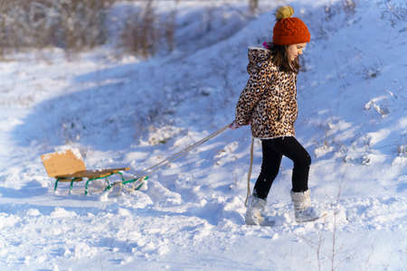 child girl throws up snow and playing in the winter forest, bright snowy fir trees, beautiful...