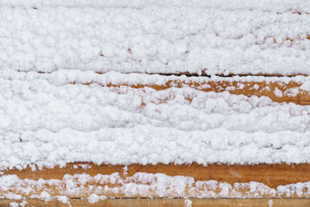 old rough wooden plank background, weathered and covered snow in winter, blizzard and snowfall