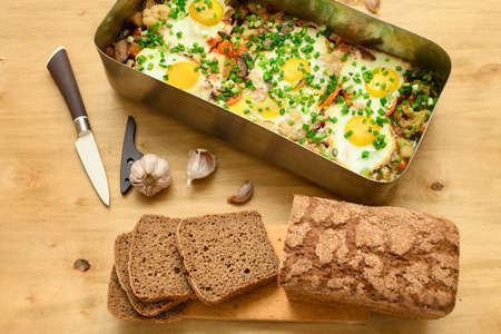 rye bread, baked mixed vegetables and eggs close view, baking tray with tomatoes, broccoli and...