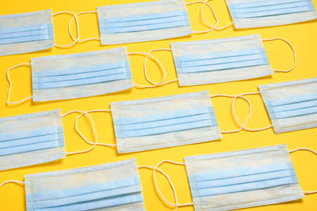 medical protective mask for respiratory protection against viruses, germs, covid or coronavirus and other infections on a yellow backgroundの写真素材