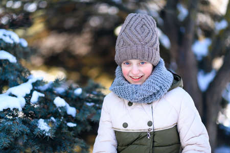 teen girl posing in winter forest, playing with snow
