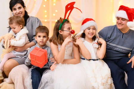 happy big family portrait - parents and children in home interior decorated with holiday lights and...