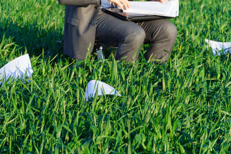 businessman works in a green field, freelance and business concept, green grass and blue sky as...