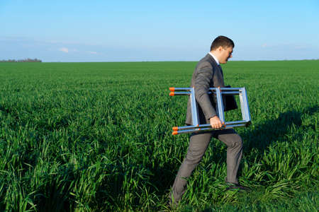 businessman sits in an office chair in a field and rests, freelance and business concept, green...