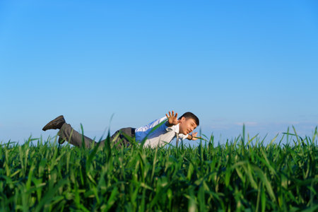 businessman sits in an office chair in a field and rests, freelance and business concept, green grass and blue sky as backgroundの写真素材