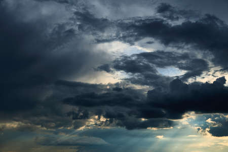 beautiful dark dramatic sky with sunlight and clouds as a background