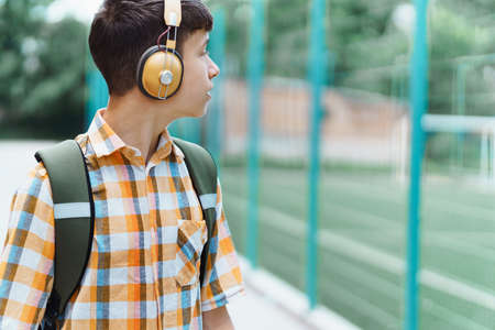 teen schoolboy on the way to the school, they use protective face masks to protect against virus,...