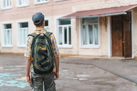 teen schoolboy on the way to the school, they use protective face masks to protect against virus,...