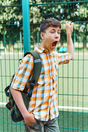 teen schoolboy on the way to the school, they use protective face masks to protect against virus,...