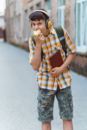 schoolboy poses in the backyard of the school, wearing a protective mask on his face from a infection, education and back to school conceptの写真素材