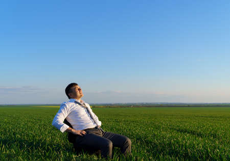 businessman works in a green field, freelance and business concept, green grass and blue sky as backgroundの写真素材