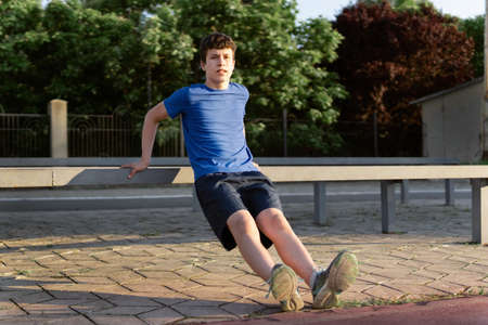 concept of sports and health - teen boy posing at a stadium, a soccer field with green grass.の写真素材