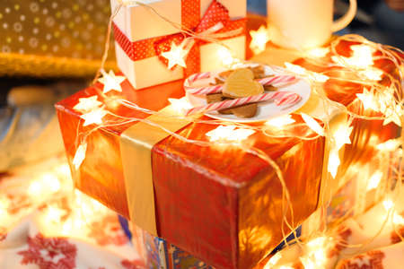 A red gift box in new year decoration for background. Holiday lights for celebrating new year.の写真素材