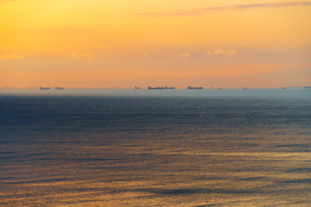silhouettes of ships at sea, dramatic seascape with sunset sky, sunlight reflected from the wavesの写真素材