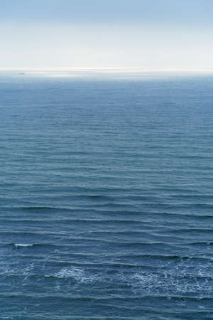sunlight is reflected in the sea, blue waves and bright light against the sky, view to the horizon