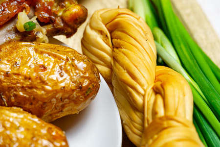 tasty and healthy food, lunch in rural style - fried chicken meat and unpeeled potatoes, eggs, green leek, salt and garlic, cooked food on a wooden kitchen boardの写真素材