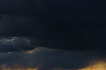 beautiful dramatic sky, bright sunlight and dark silhouette of clouds as background