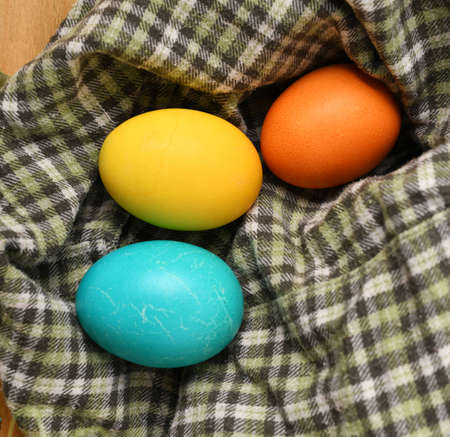 easter eggs on a checkered fabric, wooden background, holiday still life and decorations