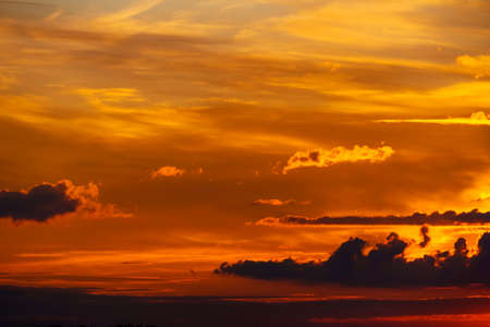 beautiful dramatic sunset sky, bright sunlight and dark silhouette of clouds as a background
