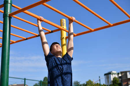 a teenage boy trains on a sports ground outdoors, he does physical exercises, a healthy lifestyle, a...