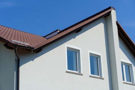 private house with white walls and roof on a blue sky background, construction concept