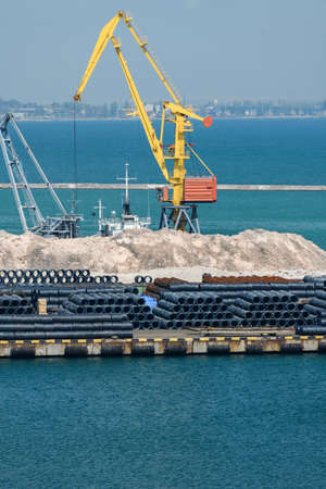 industrial seaport infrastructure, sea, cranes and minerals, metal and bundles of wire, the concept of marine cargo transportationの写真素材