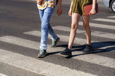 portrait of students in a city park, teenage schoolchildren a boy and a girl sitting on a bench, resting and eating applesの写真素材