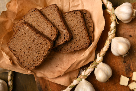still life of food in a rural style on a dark wood background, rye bread and garlic, concept of fresh vegetables and healthy foodの写真素材